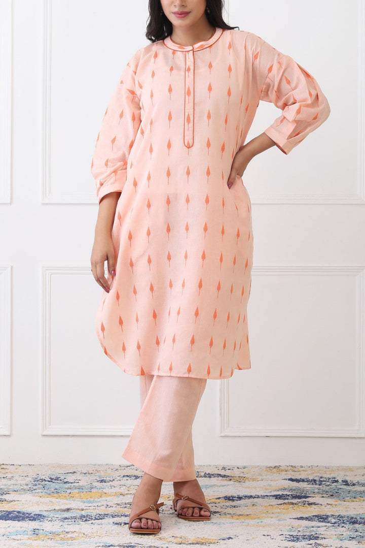 Woman wearing a peach-colored kurta with a white background