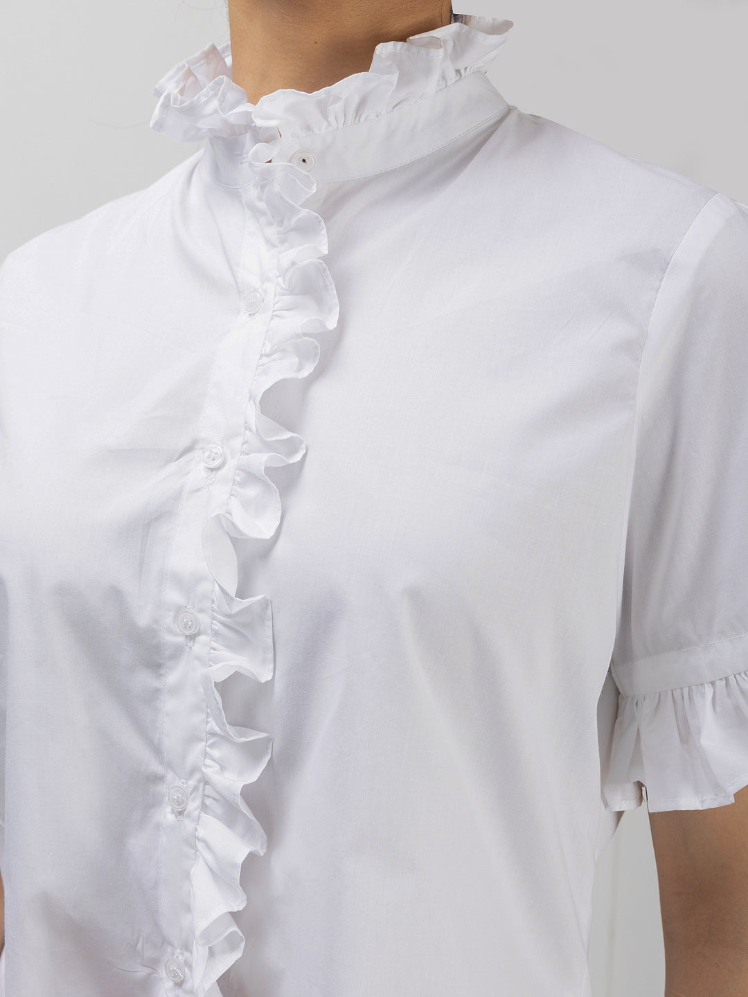 White blouse with ruffled details on a mannequin against a white background