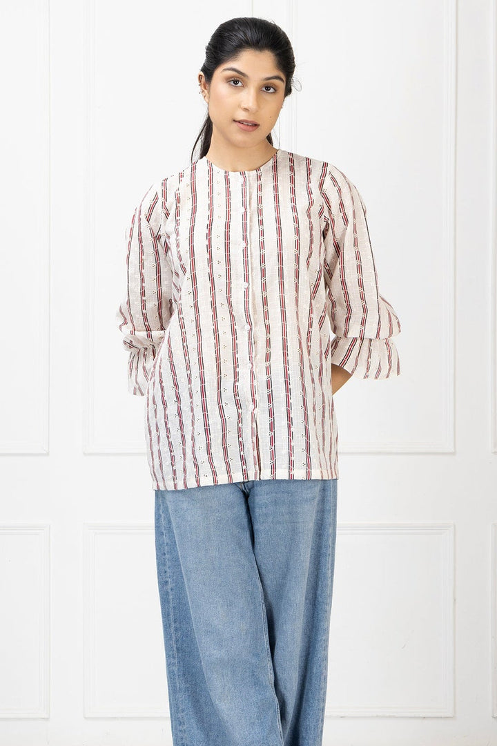 Woman wearing a striped shirt and blue jeans against a white background