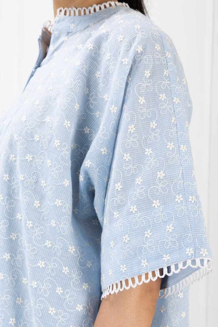 Light blue dress with white floral pattern and lace trim on a plain background