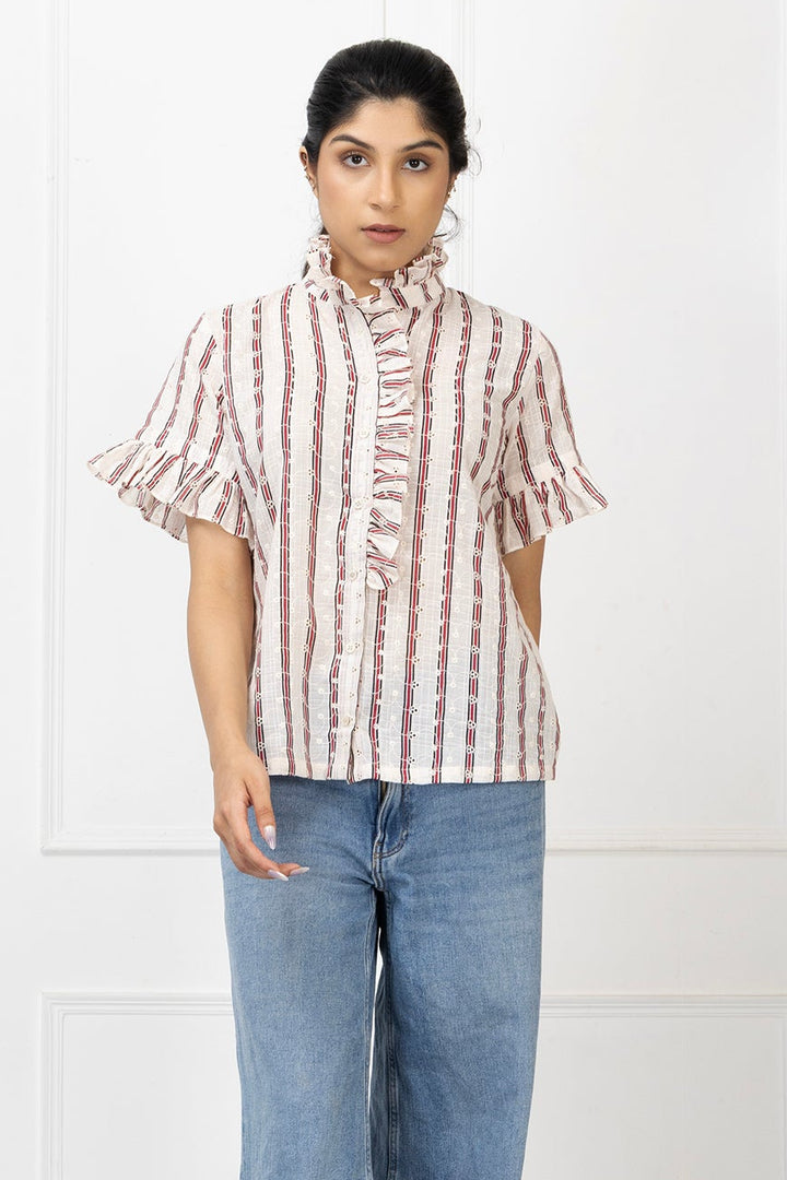 Woman wearing a striped shirt and blue jeans against a white background
