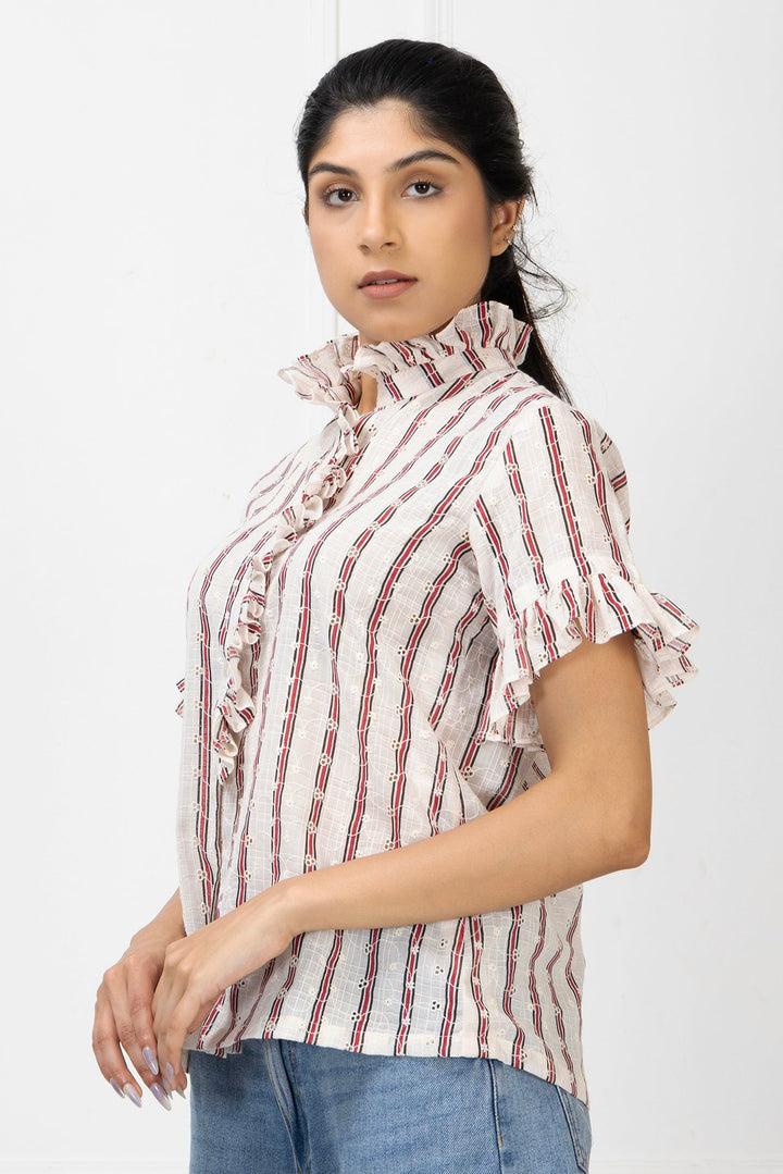 Woman wearing a white blouse with red stripes and blue jeans on a white background