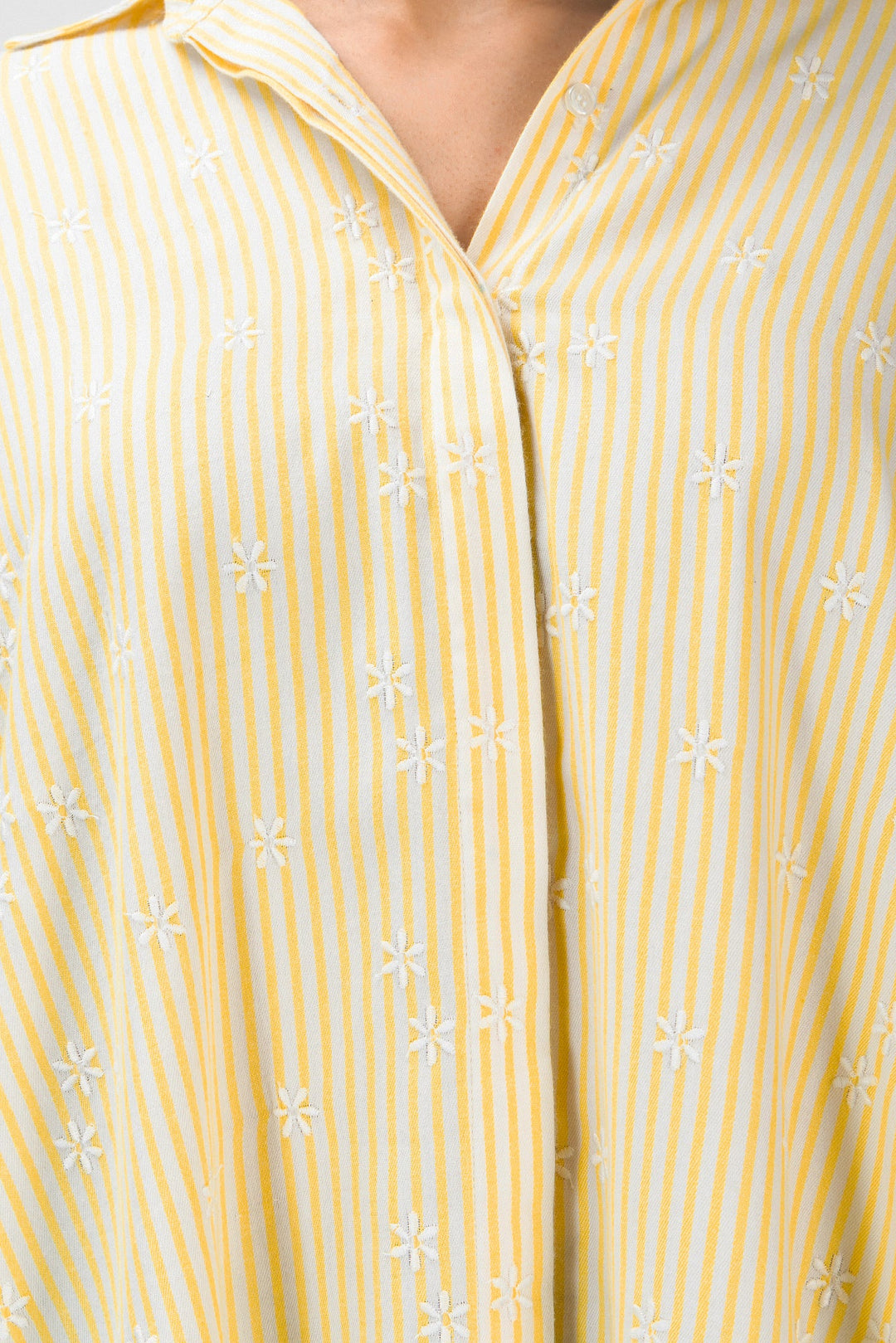 Close-up of a yellow and white striped shirt with floral patterns.