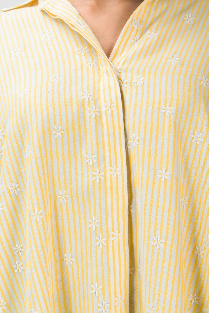 Close-up of a yellow and white striped shirt with floral patterns.