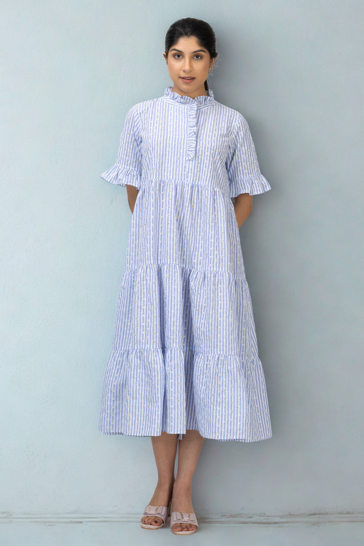 Woman wearing a blue and white striped dress against a gray background