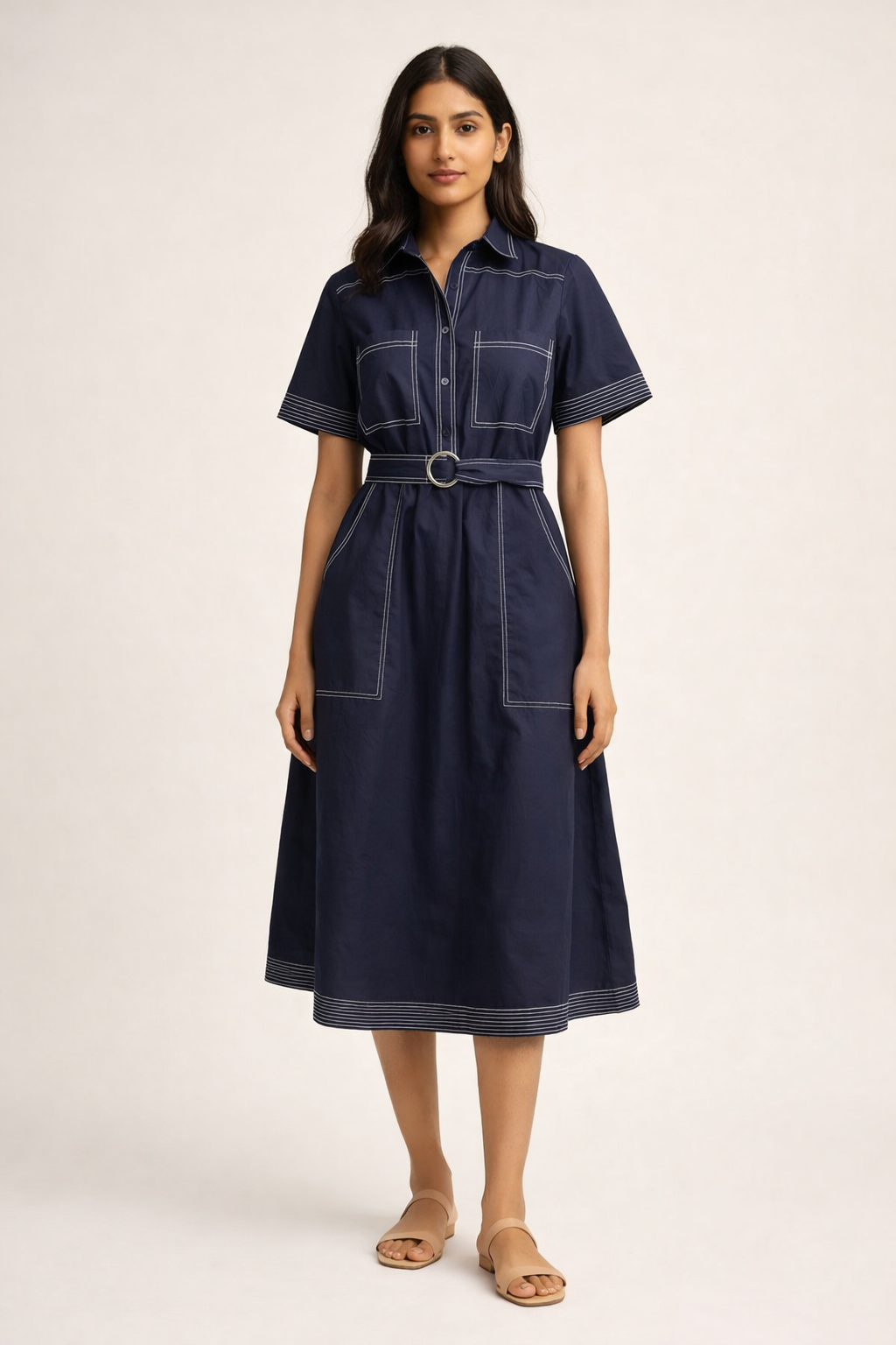 Woman wearing a navy denim dress on a plain background