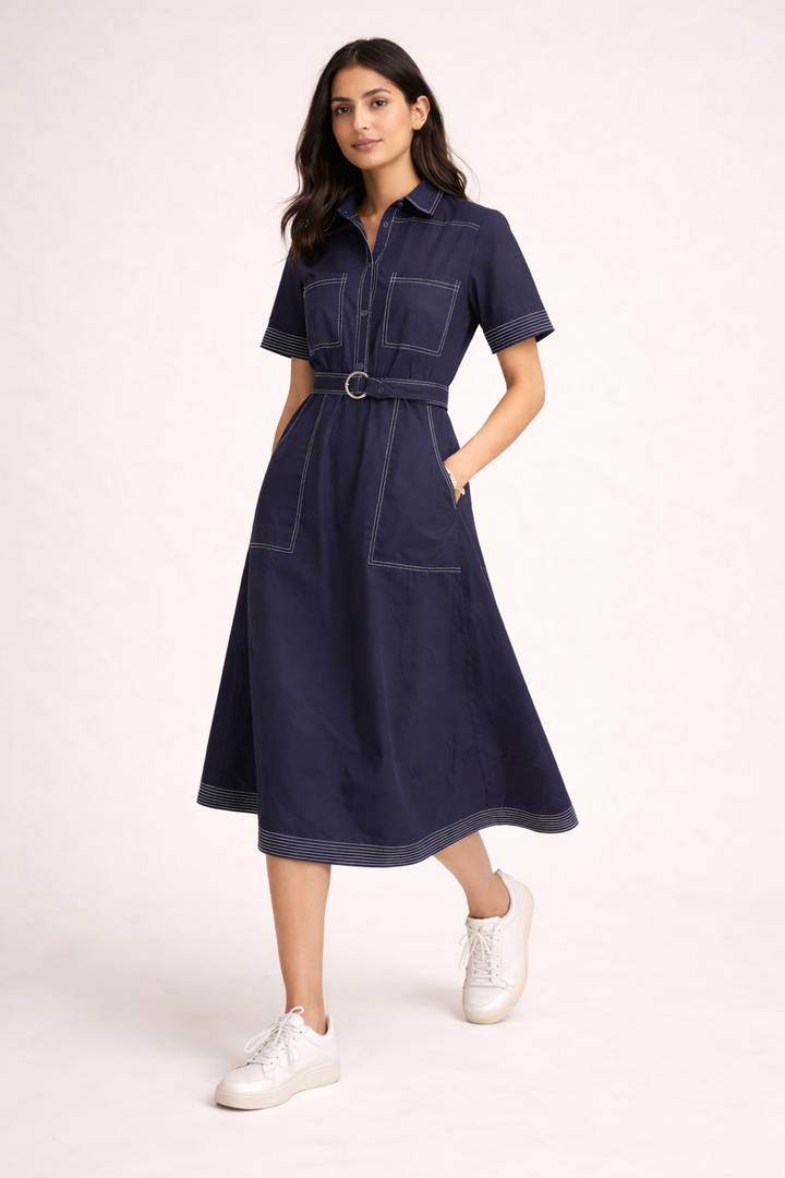 Woman wearing a navy dress with a belt on a white background