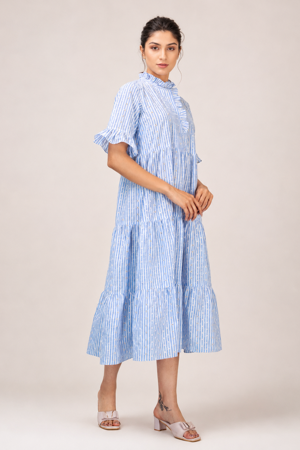 Woman wearing a blue and white striped dress on a beige background