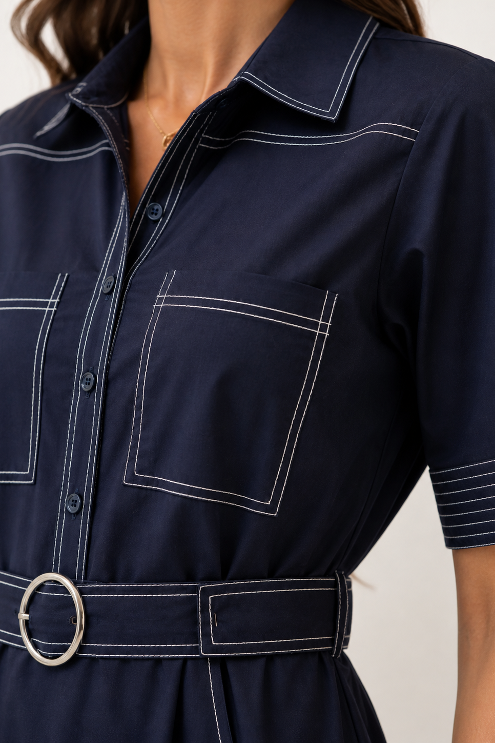 Navy blue dress  with white stitching on a neutral background