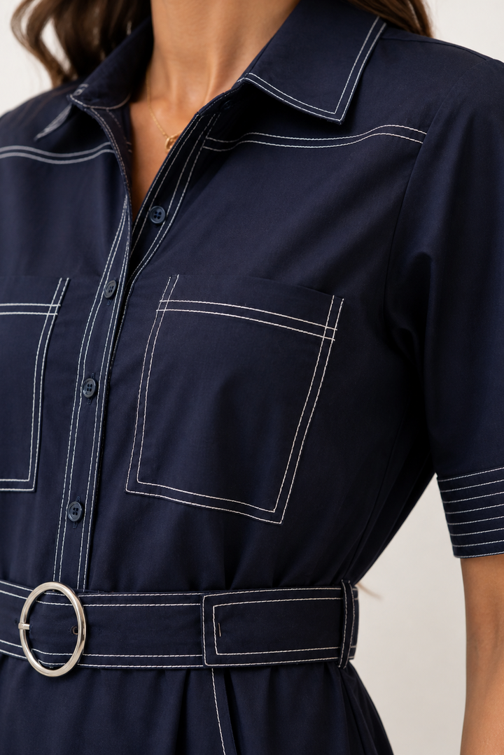 Navy blue dress  with white stitching on a neutral background