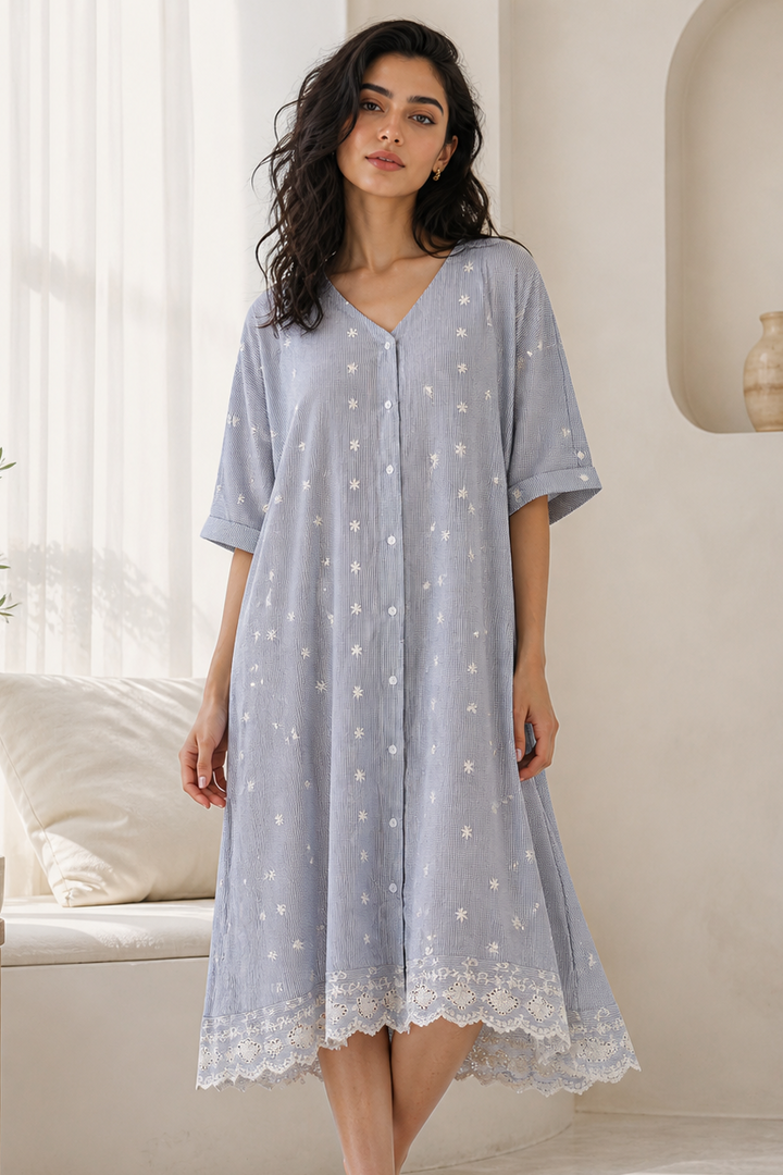 Woman wearing a light blue dress with white polka dots in a bright room.