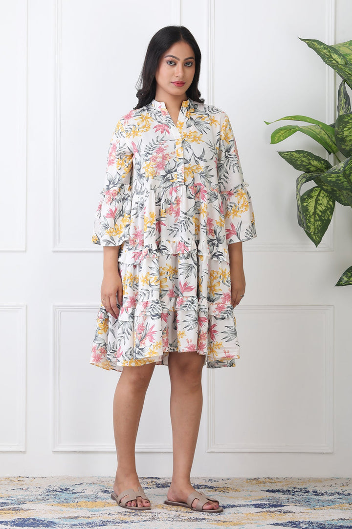 Woman wearing a floral dress standing in a room with a plant and patterned rug.