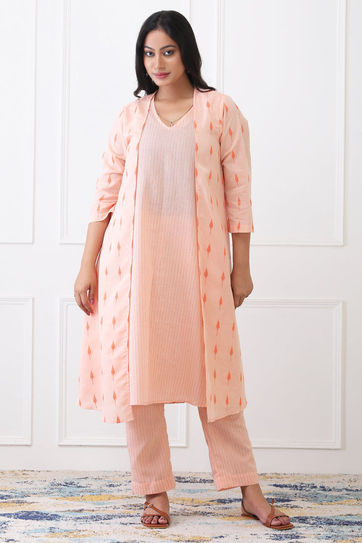 Woman wearing a peach kurta with a matching long jacket on a white background