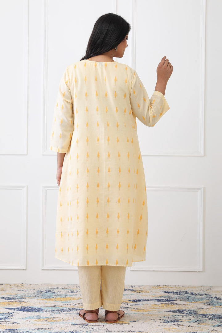 Woman wearing a yellow kurta with white patterns on a white background