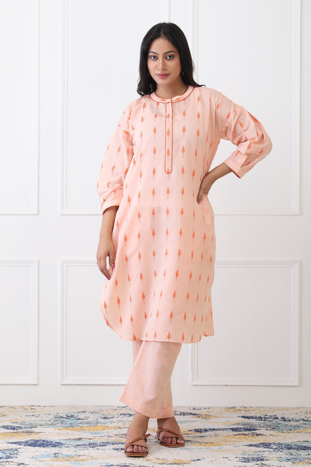 Woman wearing a peach-colored kurta with a white background