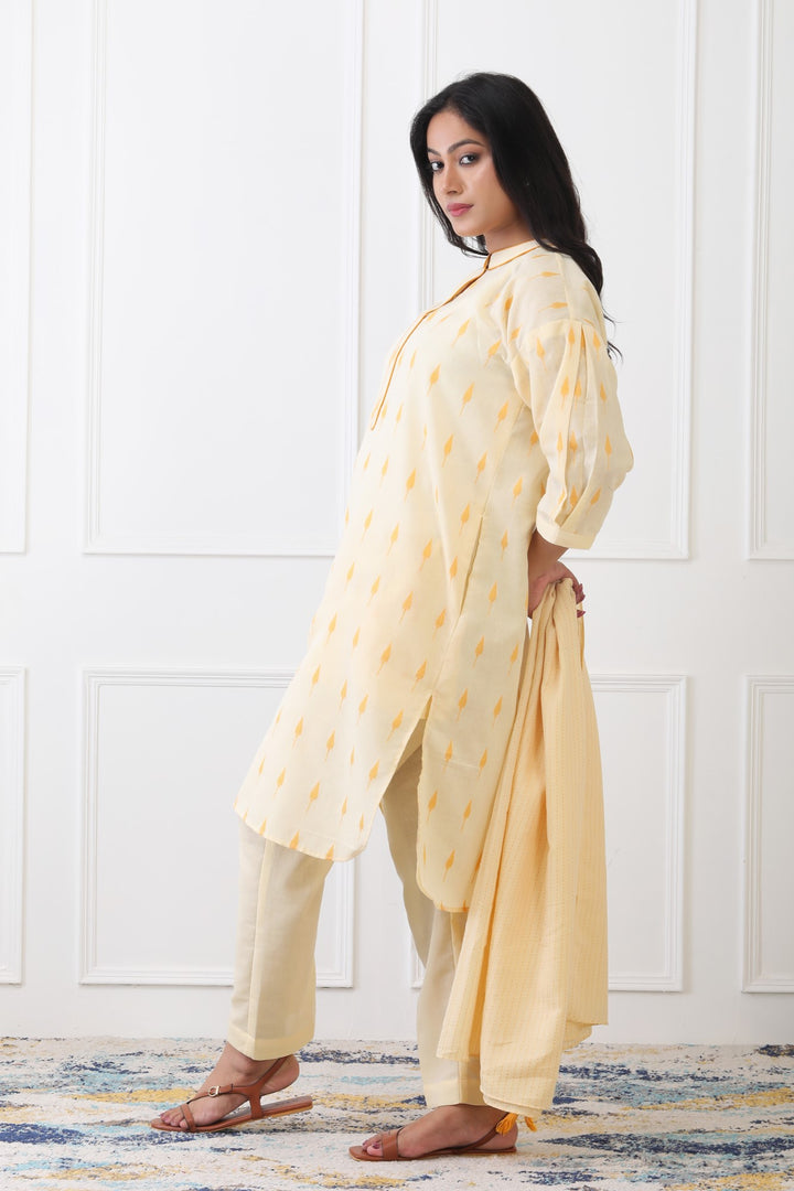 Woman wearing a light yellow traditional outfit with a white background