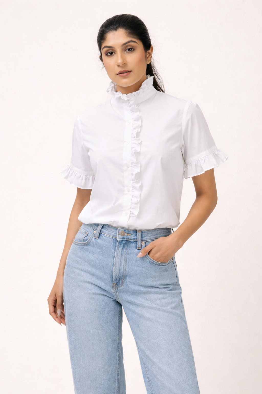 Woman wearing a white shirt and light blue jeans on a white background