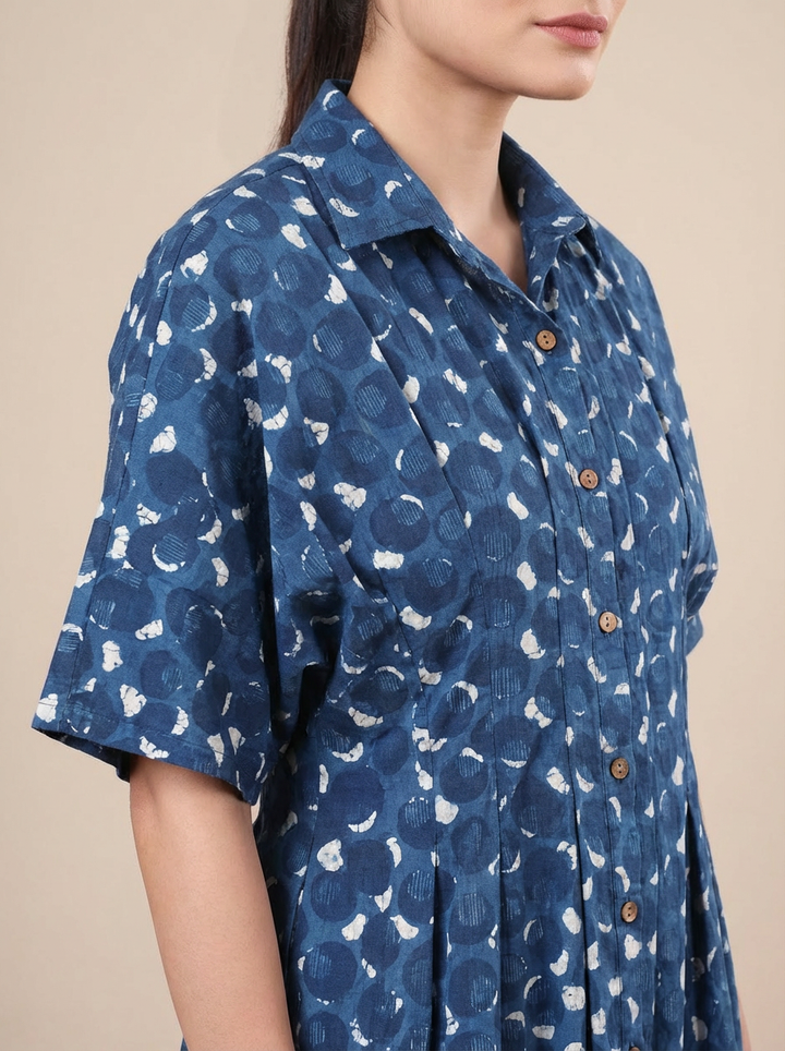 Blue patterned shirt worn by a person on a beige background