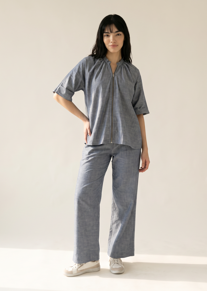 Woman wearing the Margot cotton-linen zip jacket and wide-leg trousers, hand on hip